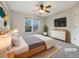 This light-filled bedroom features neutral paint, ceiling fan, a large window, and a sleek dresser with television at 2123 Tigger Ne Trce, Marietta, GA 30066