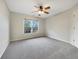 This light-filled bedroom features neutral paint, a ceiling fan, a large window, and neutral carpet at 2123 Tigger Ne Trce, Marietta, GA 30066