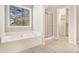Bathroom features a soaking tub, glass shower, and closet with built-in shelves at 3707 Mcguire Nw St, Kennesaw, GA 30144