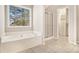 Bathroom featuring a soaking tub and glass enclosed shower with custom closet at 3707 Mcguire Nw St, Kennesaw, GA 30144