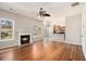 Bright living room with fireplace, ceiling fan, and hardwood floors open to the modern kitchen at 3707 Mcguire Nw St, Kennesaw, GA 30144