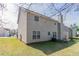 Side view of large backyard with well-maintained lawn and beige vinyl-sided two-story home at 4097 Rosebud Park Dr, Snellville, GA 30039