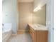 Well-lit bathroom with a tub, vanity, and a large mirror at 4097 Rosebud Park Dr, Snellville, GA 30039