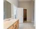 Bright bathroom featuring tile flooring, a spacious vanity with light wood cabinets and a large mirror at 4097 Rosebud Park Dr, Snellville, GA 30039