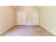 A bedroom with carpet flooring, neutral walls, double closets and a entry door at 4097 Rosebud Park Dr, Snellville, GA 30039