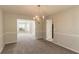 Open dining area with carpet flooring, neutral walls, and a stylish chandelier for warm ambiance at 4097 Rosebud Park Dr, Snellville, GA 30039
