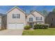 Charming two-story home featuring a well-manicured lawn, a two-car garage and traditional architecture at 4097 Rosebud Park Dr, Snellville, GA 30039