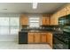 Bright kitchen features wood cabinets, black appliances, tile backsplash, and a large window at 4097 Rosebud Park Dr, Snellville, GA 30039