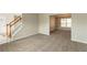 Spacious living area with neutral carpet and paint, showcasing the staircase and adjacent dining area at 4097 Rosebud Park Dr, Snellville, GA 30039