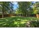 This expansive backyard features a lush lawn, mature trees, and a playground ready for outdoor activities at 788 Old Paper Mill Dr, Marietta, GA 30067