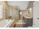 Bathroom features tile flooring, granite vanity, framed mirror, tub and frameless glass shower at 788 Old Paper Mill Dr, Marietta, GA 30067