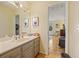 Bright bathroom featuring updated vanity, large mirror, and doorway to bedroom at 788 Old Paper Mill Dr, Marietta, GA 30067