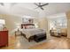 Main bedroom suite featuring a tray ceiling, ceiling fan, and sitting area with natural light at 788 Old Paper Mill Dr, Marietta, GA 30067