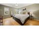 Bedroom with hardwood floors, two windows and a dark wood dresser and night stand at 788 Old Paper Mill Dr, Marietta, GA 30067