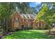 Beautiful traditional brick home with manicured lawn, mature trees, and classic shutters exudes timeless charm at 788 Old Paper Mill Dr, Marietta, GA 30067