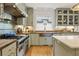 A spacious kitchen featuring custom cabinets, a copper sink, a professional range, and hardwood floors at 788 Old Paper Mill Dr, Marietta, GA 30067