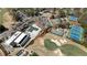 Overhead shot capturing clubhouse amenities: pool, parking, golf course, and tennis courts amidst a lush landscape at 11630 Mountain Laurel Dr, Roswell, GA 30075