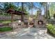 Outdoor kitchen with grill, and stone fireplace featuring a private outdoor living space at 11630 Mountain Laurel Dr, Roswell, GA 30075