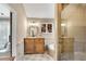 Bright bathroom with a glass-enclosed shower, wooden vanity, and natural light from a window at 11630 Mountain Laurel Dr, Roswell, GA 30075
