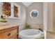 Relaxing bathroom featuring a soaking tub with tile surround, natural light, and neutral colors at 11630 Mountain Laurel Dr, Roswell, GA 30075