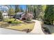 Landscaped front lawn of this charming home with a long driveway offering ample parking at 11630 Mountain Laurel Dr, Roswell, GA 30075