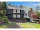 Charming exterior of a two-story home featuring dark siding, a stone chimney, and beautiful landscaping at 11630 Mountain Laurel Dr, Roswell, GA 30075