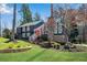 Charming exterior view showcasing a two-story home with dark siding, stone details, and a well-maintained lawn at 11630 Mountain Laurel Dr, Roswell, GA 30075