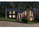 This two-story home features a stone chimney and well-lit landscaping in the evening at 11630 Mountain Laurel Dr, Roswell, GA 30075