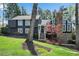 Beautifully landscaped front yard of a two-story home with a stone chimney and mature trees at 11630 Mountain Laurel Dr, Roswell, GA 30075
