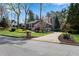 Street view of home with manicured front lawn, mature trees, and a charming facade with stone chimney at 11630 Mountain Laurel Dr, Roswell, GA 30075