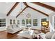 Sunlit living room with vaulted ceilings, hardwood floors, and large windows overlooking the backyard at 11630 Mountain Laurel Dr, Roswell, GA 30075