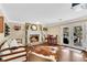 Living room with a stone fireplace, hardwood floors, and French doors leading to outdoor area at 11630 Mountain Laurel Dr, Roswell, GA 30075