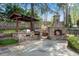 An outdoor kitchen and stone fireplace create a delightful backyard space for cooking and entertaining at 11630 Mountain Laurel Dr, Roswell, GA 30075
