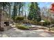 This stone patio features a built-in fire place and hot tub, nestled in a private wooded backyard at 11630 Mountain Laurel Dr, Roswell, GA 30075