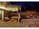 Charming outdoor patio with string lights, swing, grill, and seating area, illuminated at night at 11630 Mountain Laurel Dr, Roswell, GA 30075