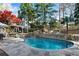 Enjoy this backyard oasis with an in-ground pool and elegant stone landscaping and patio at 11630 Mountain Laurel Dr, Roswell, GA 30075