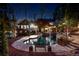 Lush backyard showcasing a pool with a waterfall feature, lounge area, and landscaped surroundings at night at 11630 Mountain Laurel Dr, Roswell, GA 30075