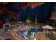 Inviting backyard featuring a stunning pool, spa, fireplace, and manicured landscaping at night at 11630 Mountain Laurel Dr, Roswell, GA 30075