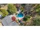 Aerial view of a kidney-shaped pool featuring a spa, lounge chairs, and meticulously manicured landscaping at 11630 Mountain Laurel Dr, Roswell, GA 30075