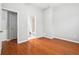 A bright bedroom showcases beautiful hardwood floors with two doorways on opposite sides of the room at 3317 Regent Sw Pl, Atlanta, GA 30311
