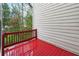 Outdoor deck with red painted wood and rail overlooks a scenic, wooded landscape at 3317 Regent Sw Pl, Atlanta, GA 30311