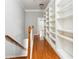 Hallway with beautiful hardwood floors, bookshelves on the wall, and stairs at 3317 Regent Sw Pl, Atlanta, GA 30311