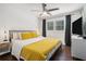 Bedroom with hardwood floors, white walls, bedside tables, lamps, and white and yellow bedding at 403 Red Oak Ln, Lawrenceville, GA 30046