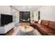 Open-concept living room with modern furniture, hardwood floors, and a decorative accent wall at 403 Red Oak Ln, Lawrenceville, GA 30046