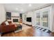 Bright living room featuring a leather couch, fireplace, hardwood floors, and natural lighting at 403 Red Oak Ln, Lawrenceville, GA 30046