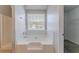 Bathroom with large soaking tub, window, and access to the walk-in closet at 705 Brentwood Pkwy, Stockbridge, GA 30281
