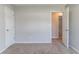 Neutral-toned bedroom with plush carpeting and open doorway, offering a calm and inviting atmosphere at 705 Brentwood Pkwy, Stockbridge, GA 30281