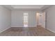 Large bedroom with tray ceiling, carpet floors, and entrances to the bathroom and walk-in closet at 705 Brentwood Pkwy, Stockbridge, GA 30281