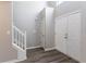Bright foyer features wood-look flooring, white trim staircase, and multiple coat closets at 705 Brentwood Pkwy, Stockbridge, GA 30281
