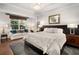 Bright bedroom featuring a plush bed, a cozy seating area by the window and warm hardwood floors at 850 Piedmont Ne Ave # 1206, Atlanta, GA 30308